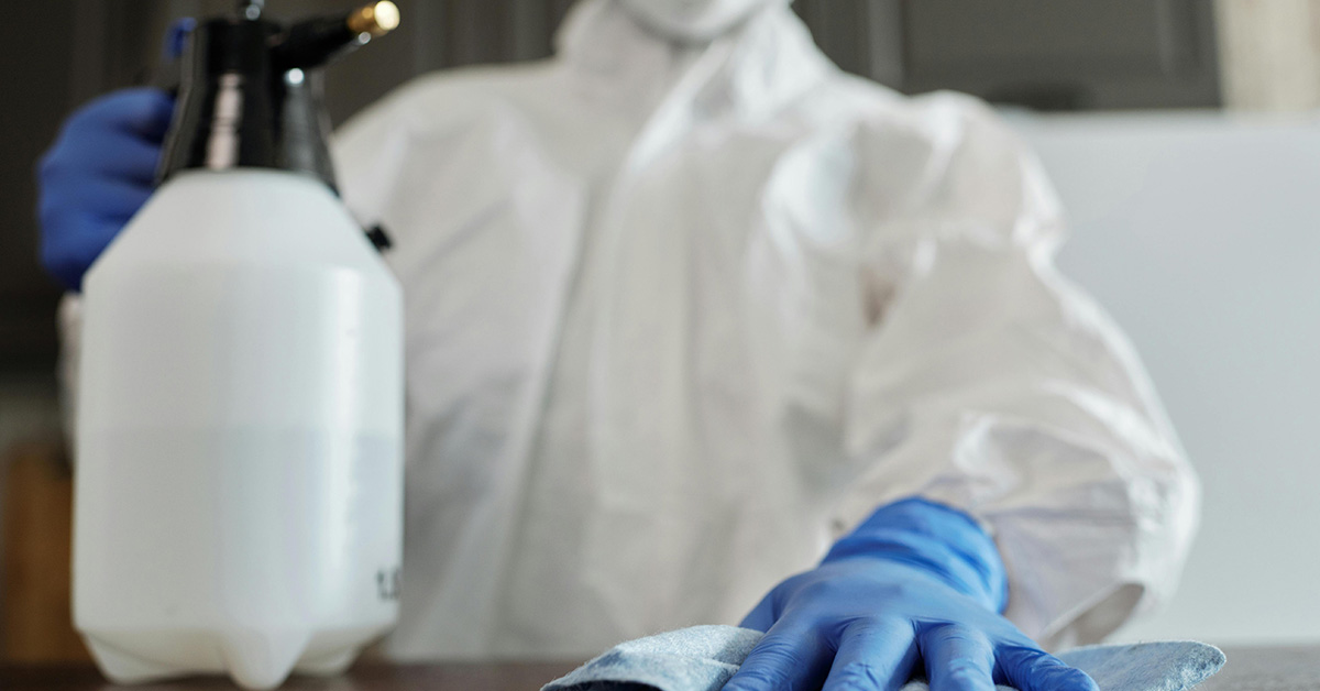 Spray bottle and cleaning cloth in hands